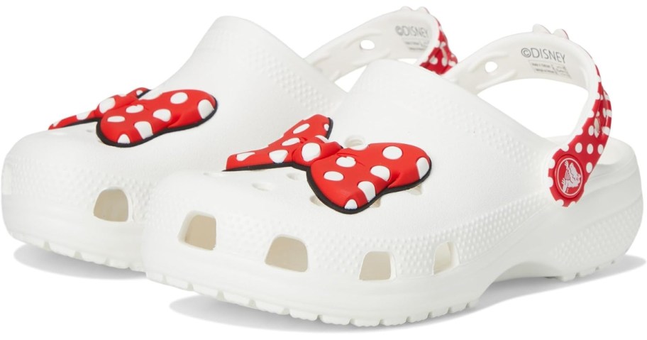 a pair of white Crocs with pink and red Minnie Mouse bows 