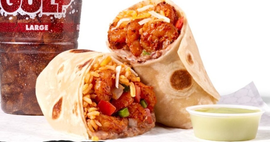 burrito cut in half next to fountain soda