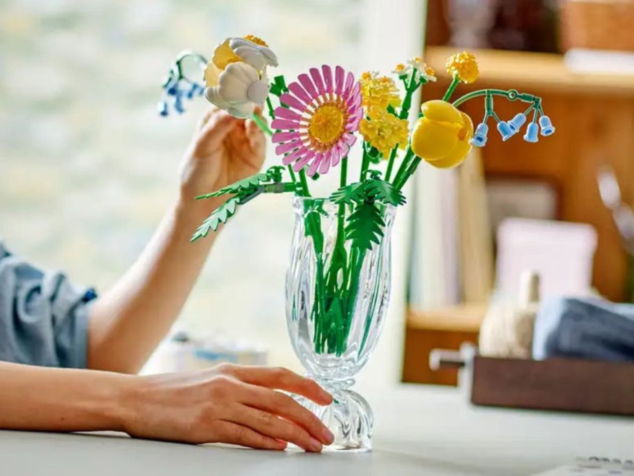 A person building Botanicals Petite Sunny Bouquet