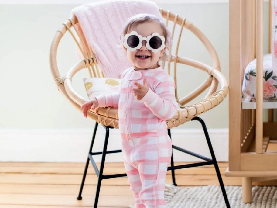 A little girl in sunglasses smiling for the camera