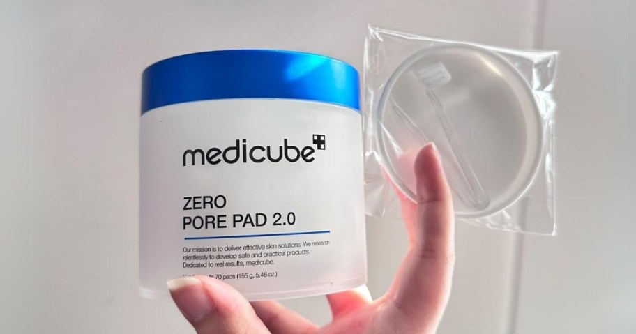 hand holding a container of Medicube Zero Pore Pads with a single pad 