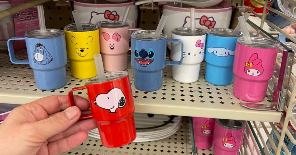 Person holding up mini tumblers at Hobby lobby featuring Snoopy, Winnie the Pooh and more