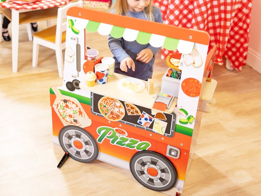 girl playing with wooden pizza food truck toy