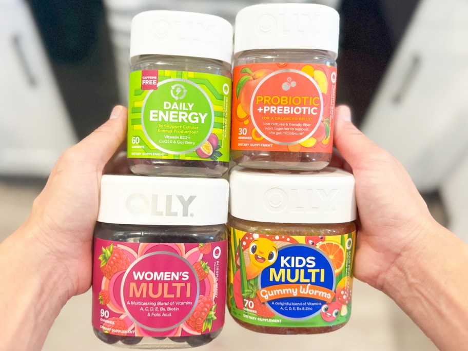 hands holding 4 jars of Olly vitamins