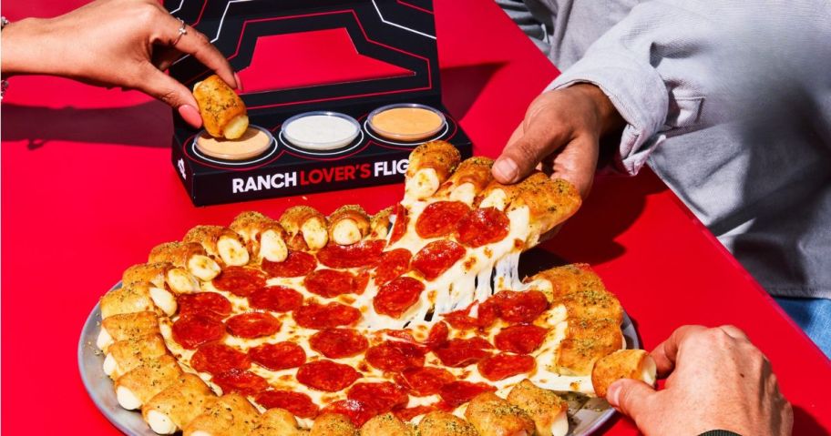 People eating a Cheesy Bites Pizza from Pizza Hut