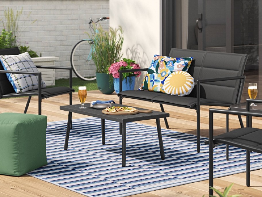 Padded sling patio conversation 4 piece set displayed on a rug