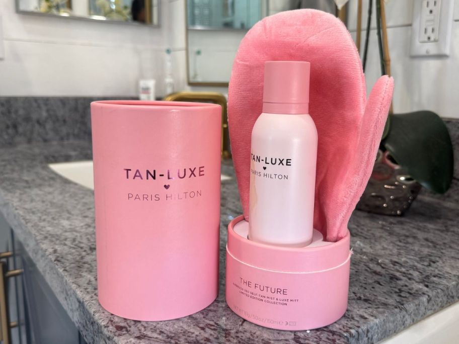 Tan-Luxe Paris Hilton Spray & Mitt set on a bathroom counter