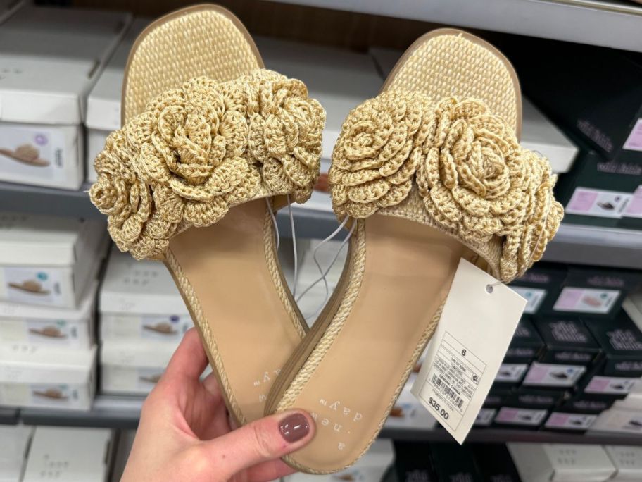 Hand holding a pair of A New Day Women's Coco Raffia Flower Slide Sandals 