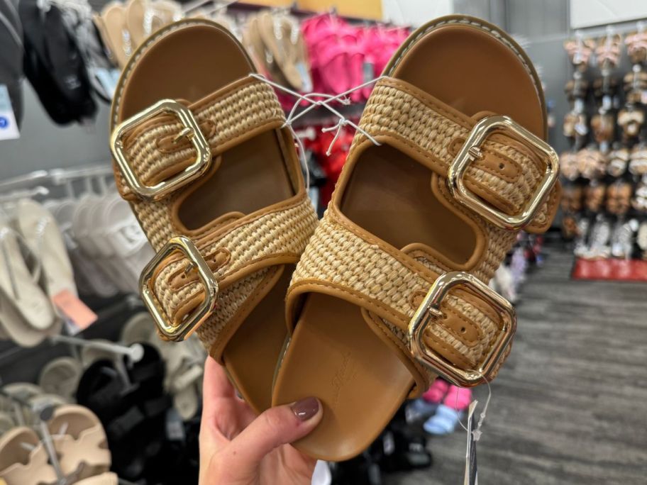 Hand holding a pair of Universal Thread  Women's Collin Double Buckle Footbed Sandals