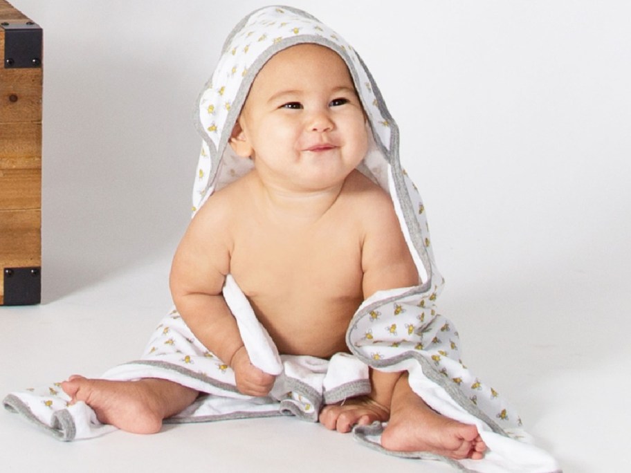 baby using burt's bees towel in grey and with stars