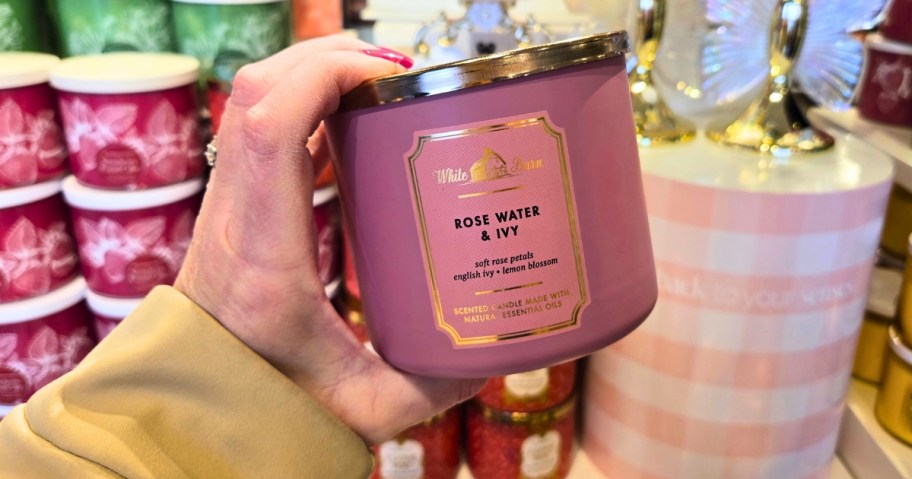 hand holding a pink jar candle