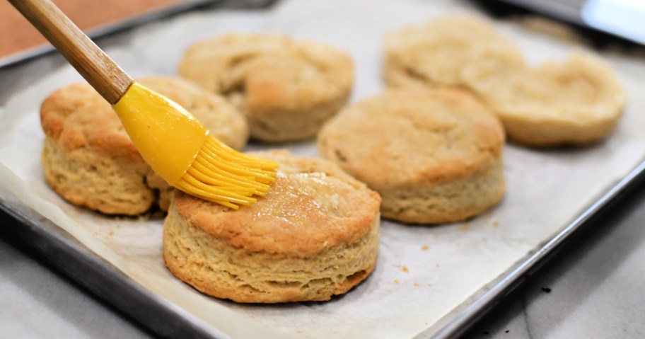 brushing butter on sourdough biscuits 