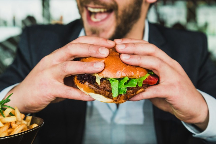man laughing holding burger