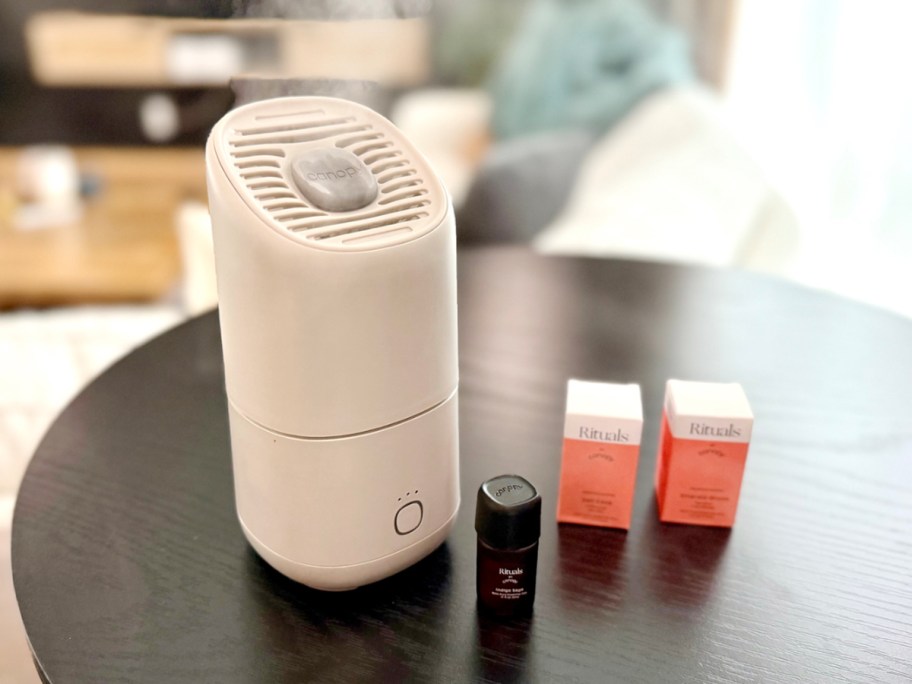 white canopy portable humidifier on table with aroma sample and two boxes