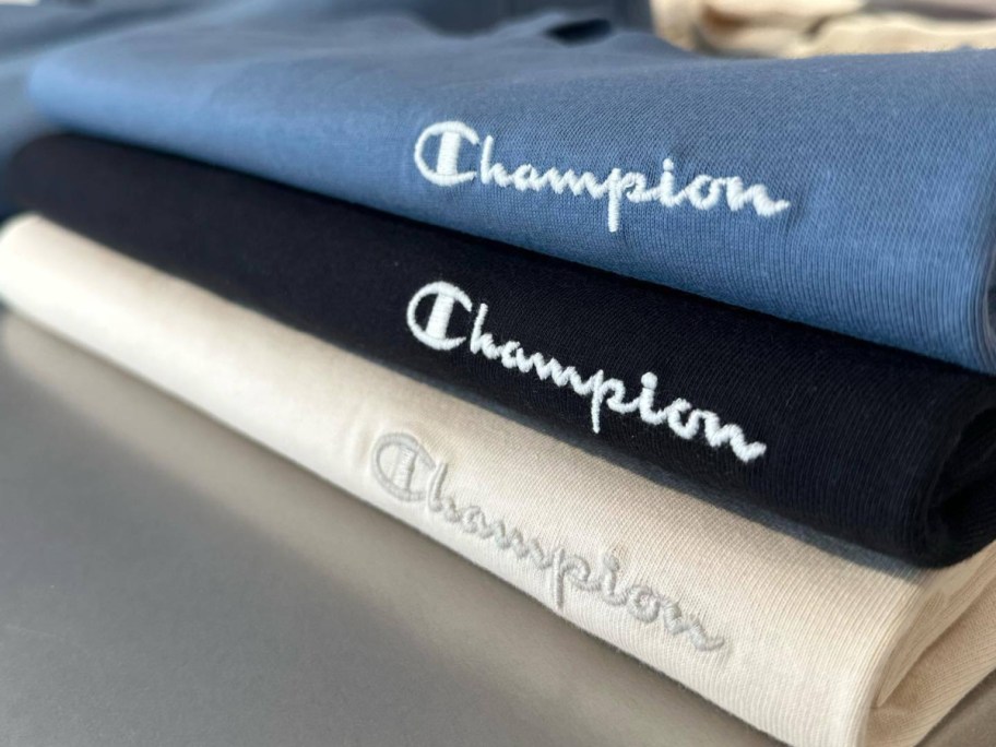 three folded Champion sweatshirts
