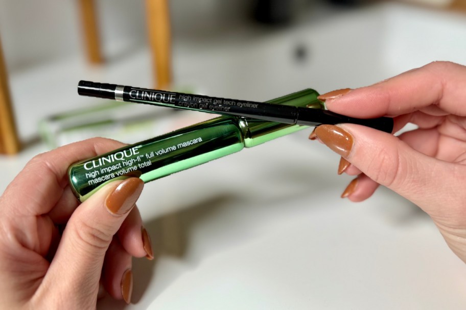 hands holding green mascara tube and eyeliner