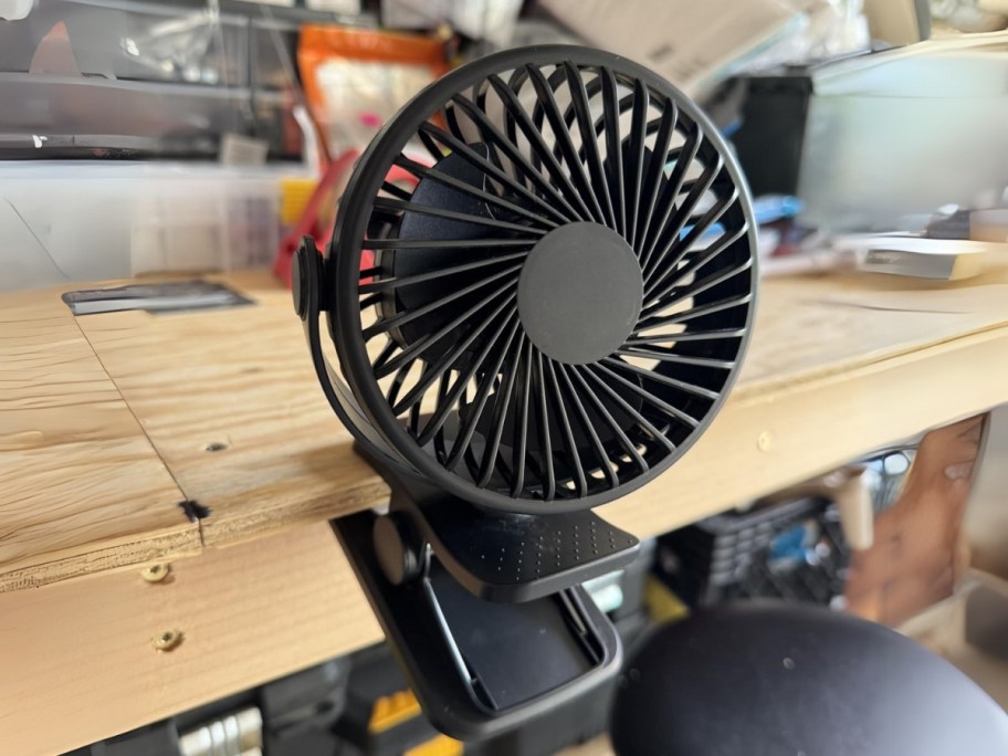 a clip on mini fan on a garage work bench