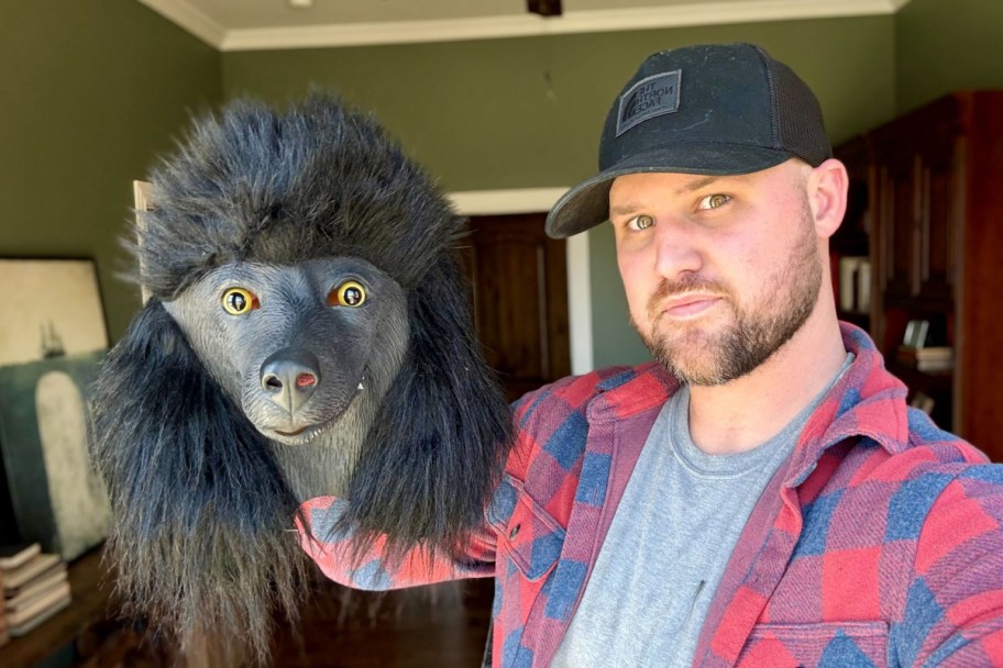 man holding black poodle dog mask