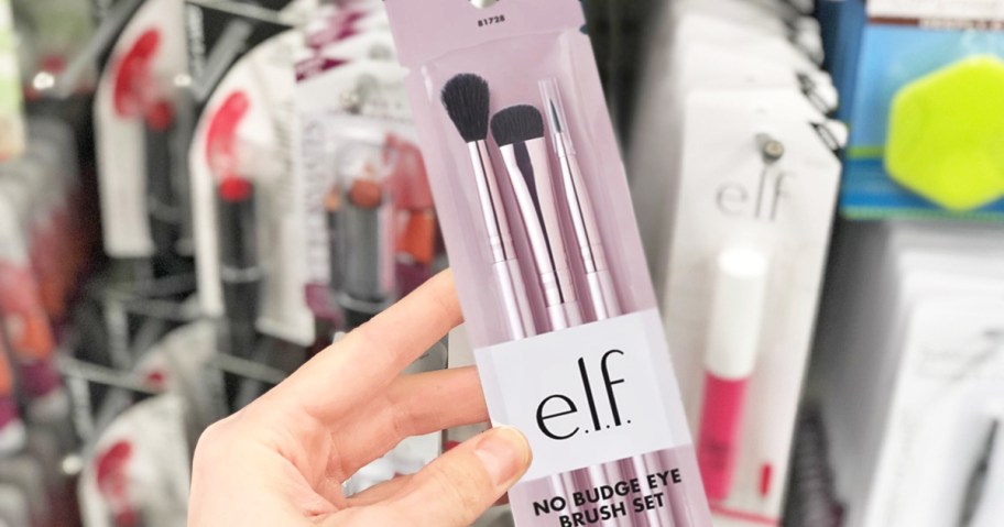 hand holding a pink makeup brush set in store