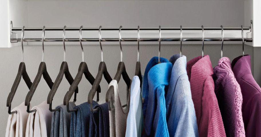 The Home Edit Thin Clothing Hangers in closet with clothes hanging off of them