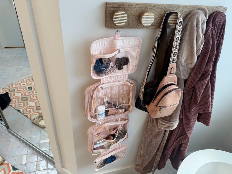 light pink toiletry bag hanging from hooks