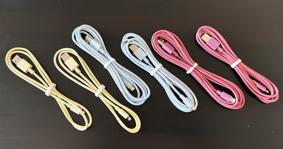 6 yellow, blue, and pink charging cables on a table