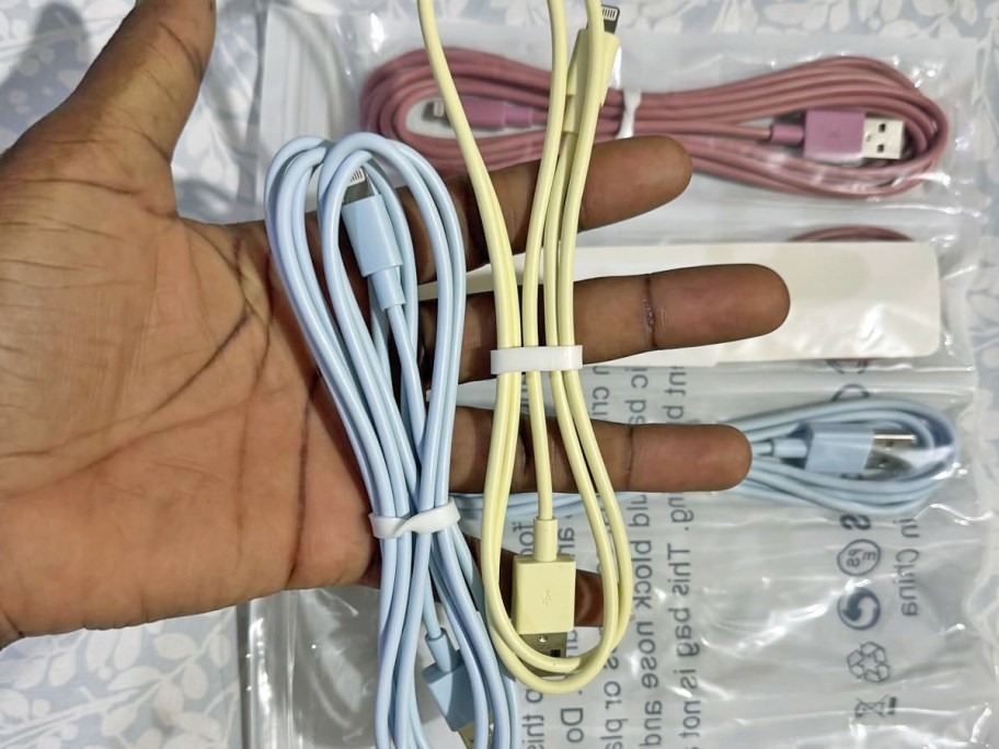 hand holding blue and yellow charging cables