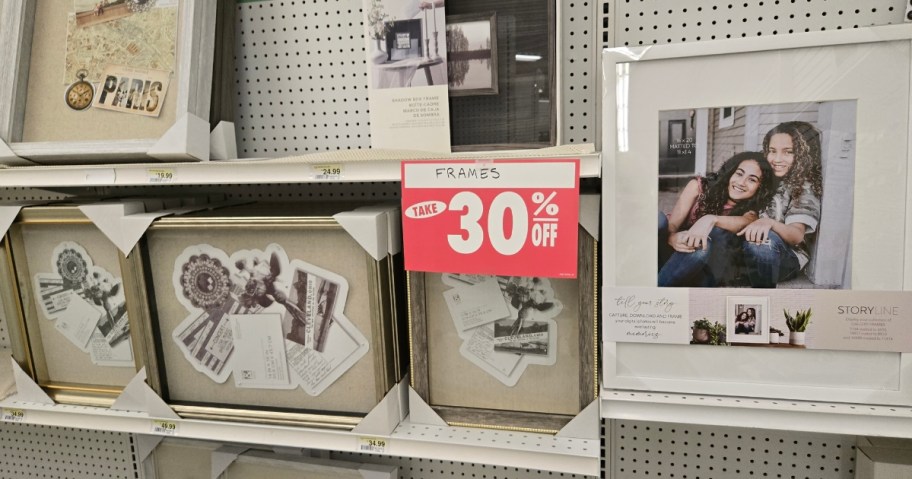 a store aisle with framed art prints and a red sign that says "30% Off"