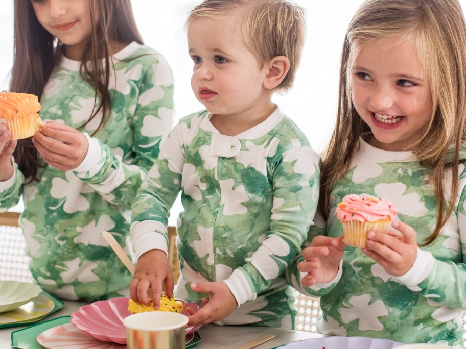 kids wearing burts bees st. patricks day pajamas while eating a cupcake