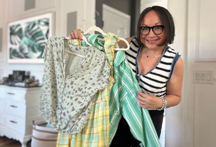 woman holding spring clothes on hangers