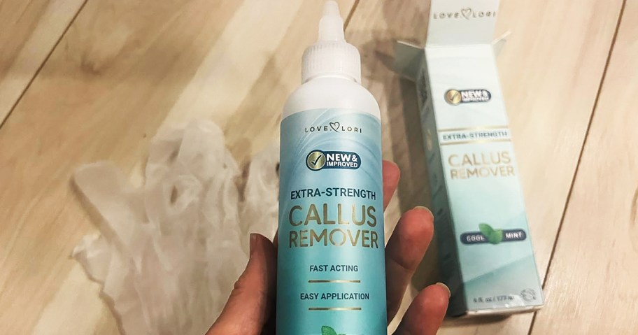 hand holding a bottle of callus remover
