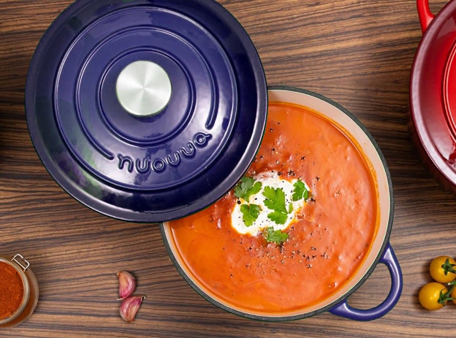 dark blue dutch oven with tomato soup on counter