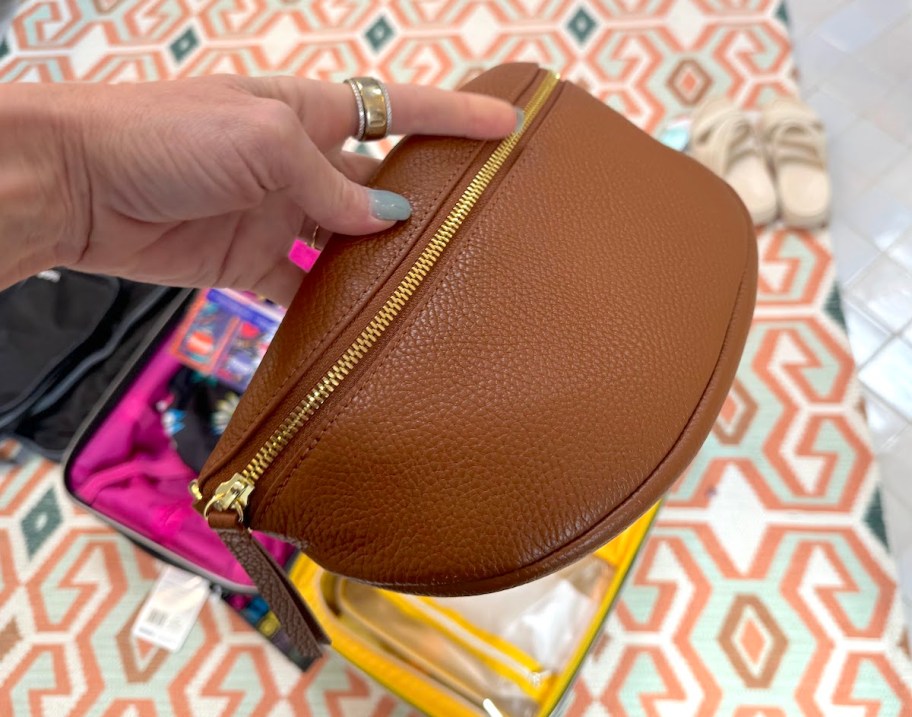 hand holding brown leather belt bag
