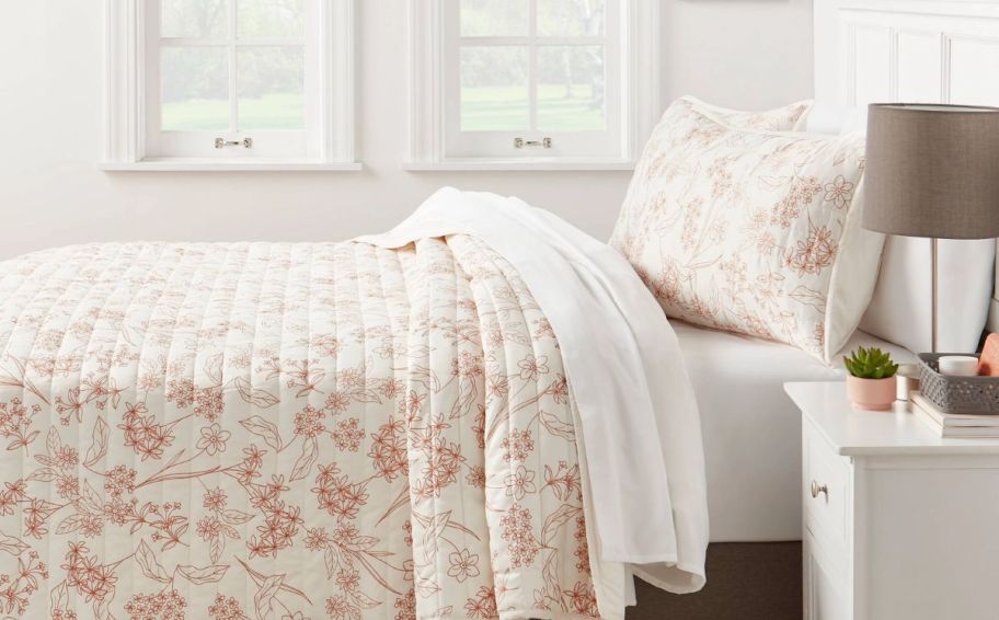 room essentials satin quilt and matching shams on a bed