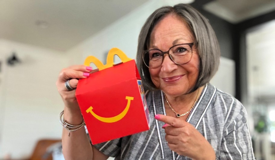 senior citizen holding a mcdonald's happy meal