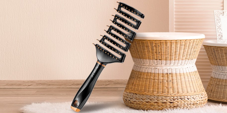 black hair brush laying against stool