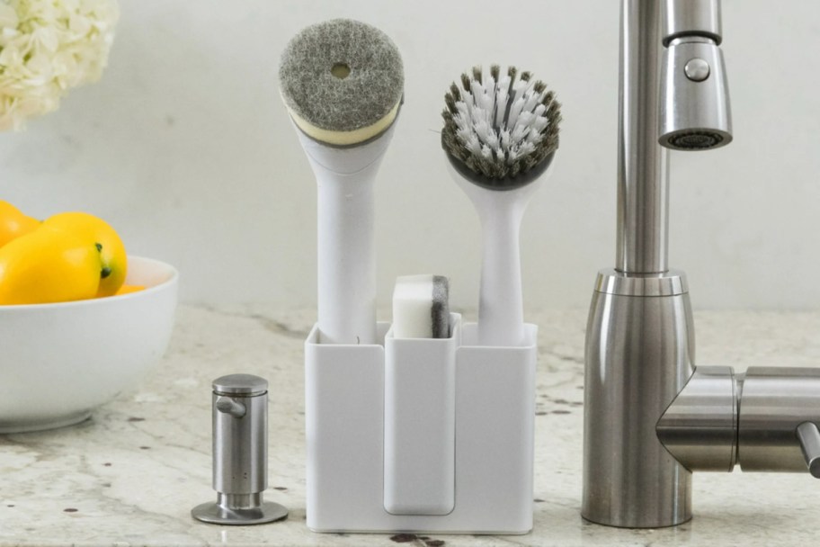 white sink caddy holding brushes and sponge