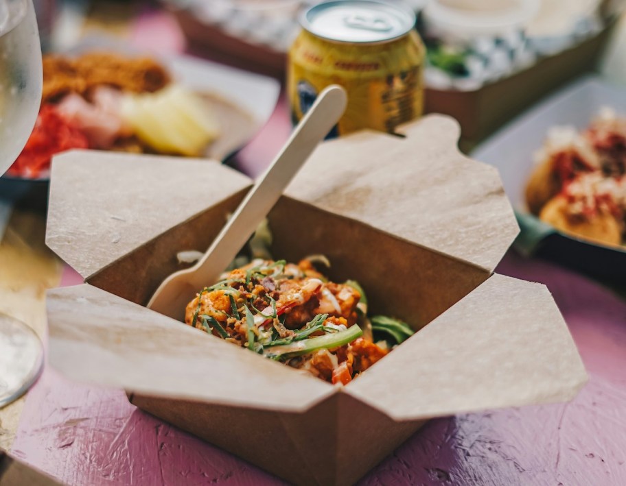 close up of to go box on restaurant table with food inside