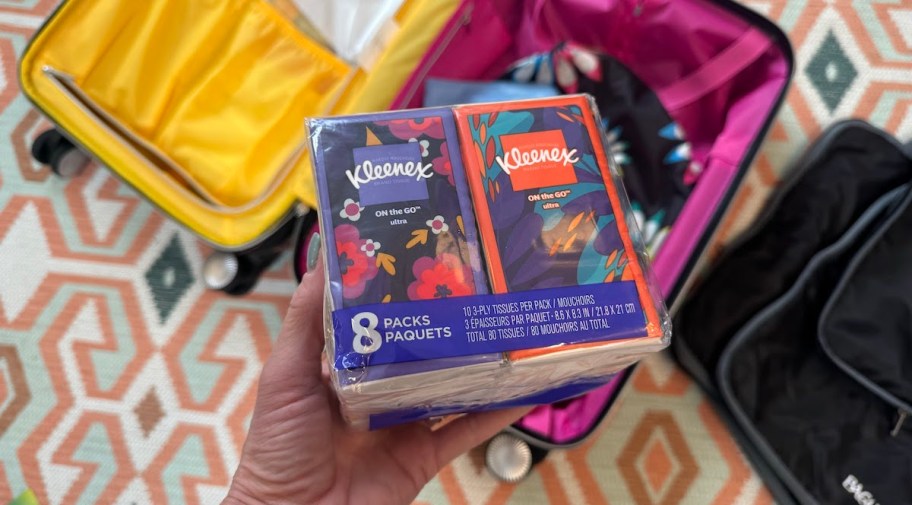 hand holding pack of travel sized kleenex tissues