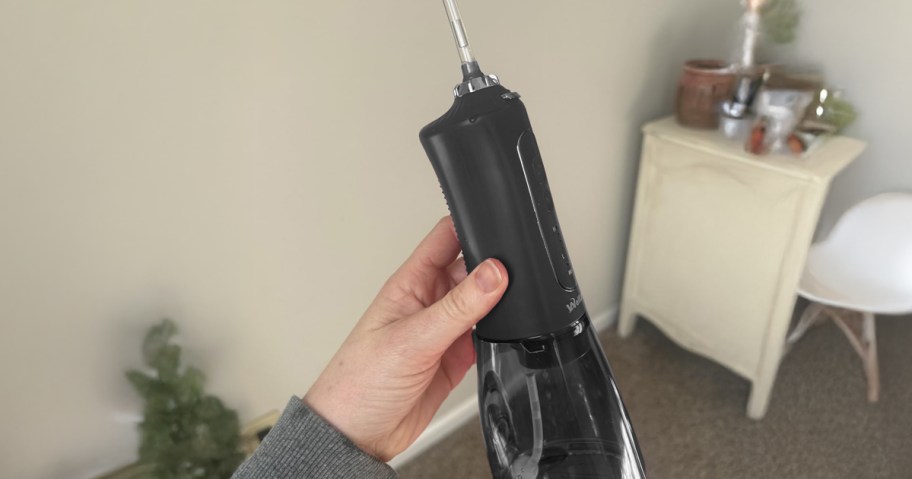 hand holding a black water flosser