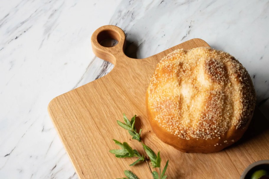 sourdough loaf of bread on wood cutting board