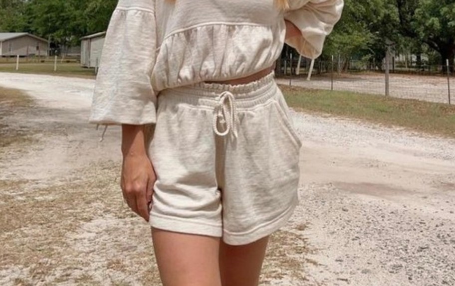 close up of woman outside wearing cream sweat outfit