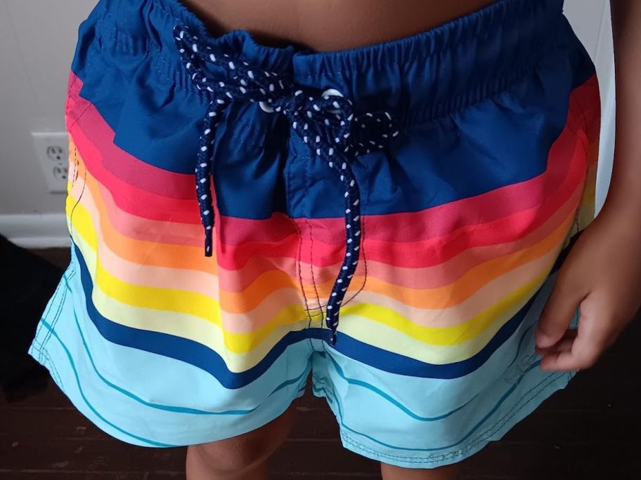 A boy wearing a pair of Angel Season Boys Swim Trunk