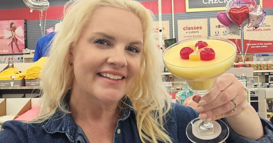 A woman holding a candle that looks like a drink