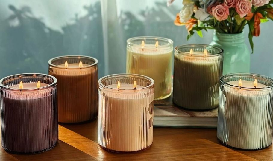 ribbed glass jar candles on coffee table with vase of flowers