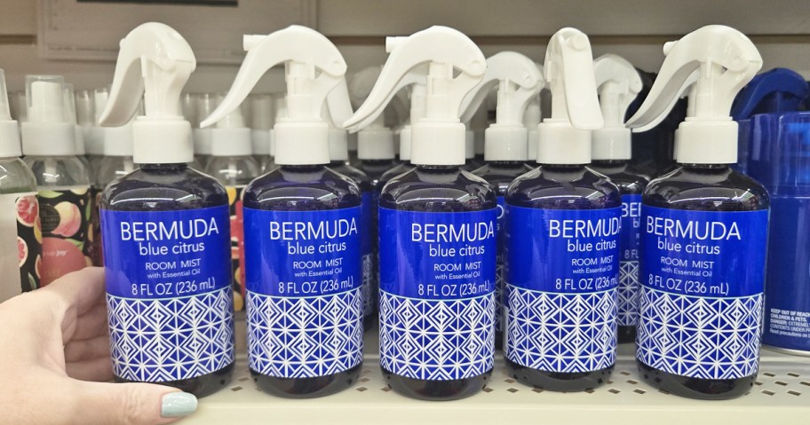 hand touching a shelf full of Bermuda Blue Citrus Room Sprays