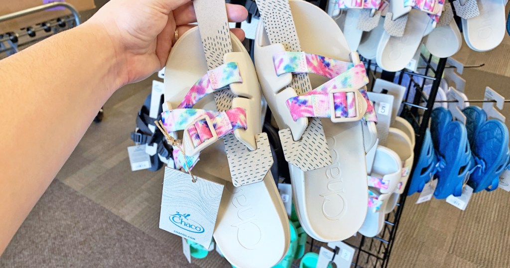 hand holding pair of Chacos sandals in store
