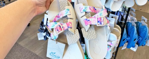hand holding pair of Chacos sandals in store