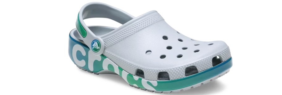 grey clog with teal sole that says crocs