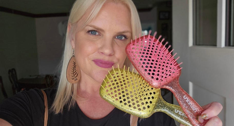 blonde woman holding up two unbrushes in pink and yellow